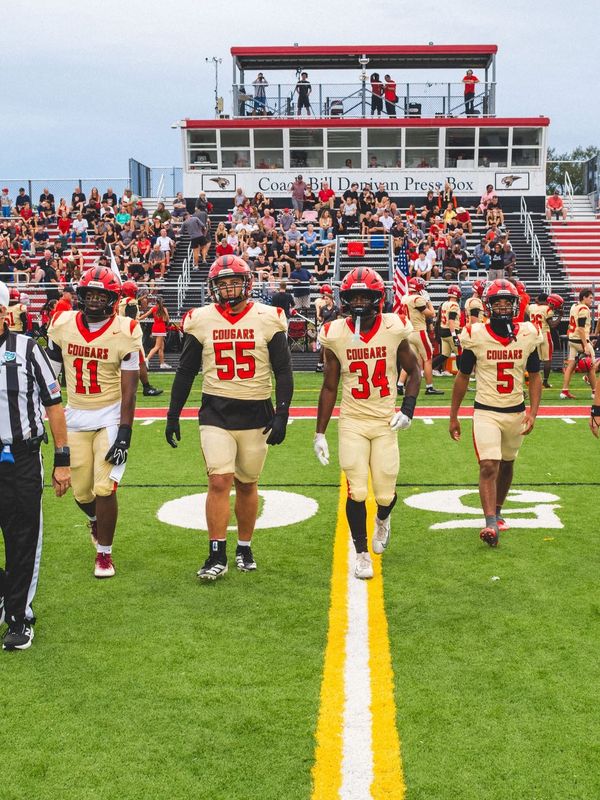 Jack Naylon, number 55, walking onto the field with Cardinal Mooney Cougars teammates before a high school football game.